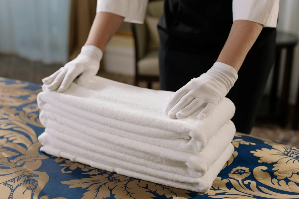 A hospitality trainee folding towels during a training session in London to develop practical skills for career advancement.