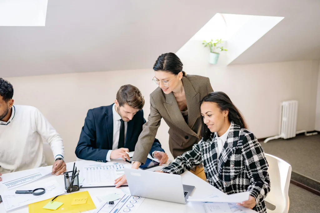 Group of professionals collaborating in a modern office, discussing documents and brainstorming ideas during a meeting.