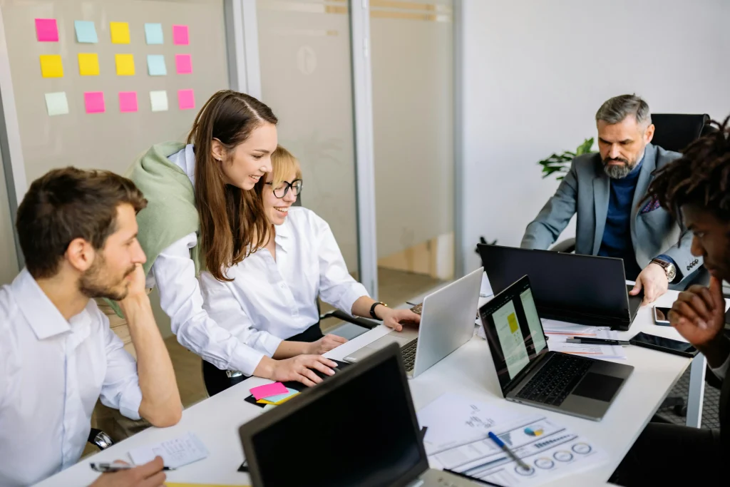 Business professionals strategizing and reviewing data about Zero-Hour Contract Rules in a collaborative workspace with sticky notes and laptops.